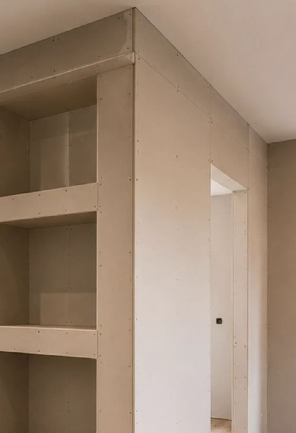 Estantería de pladur a medida integrada en una pared, con huecos y remates cuidados
